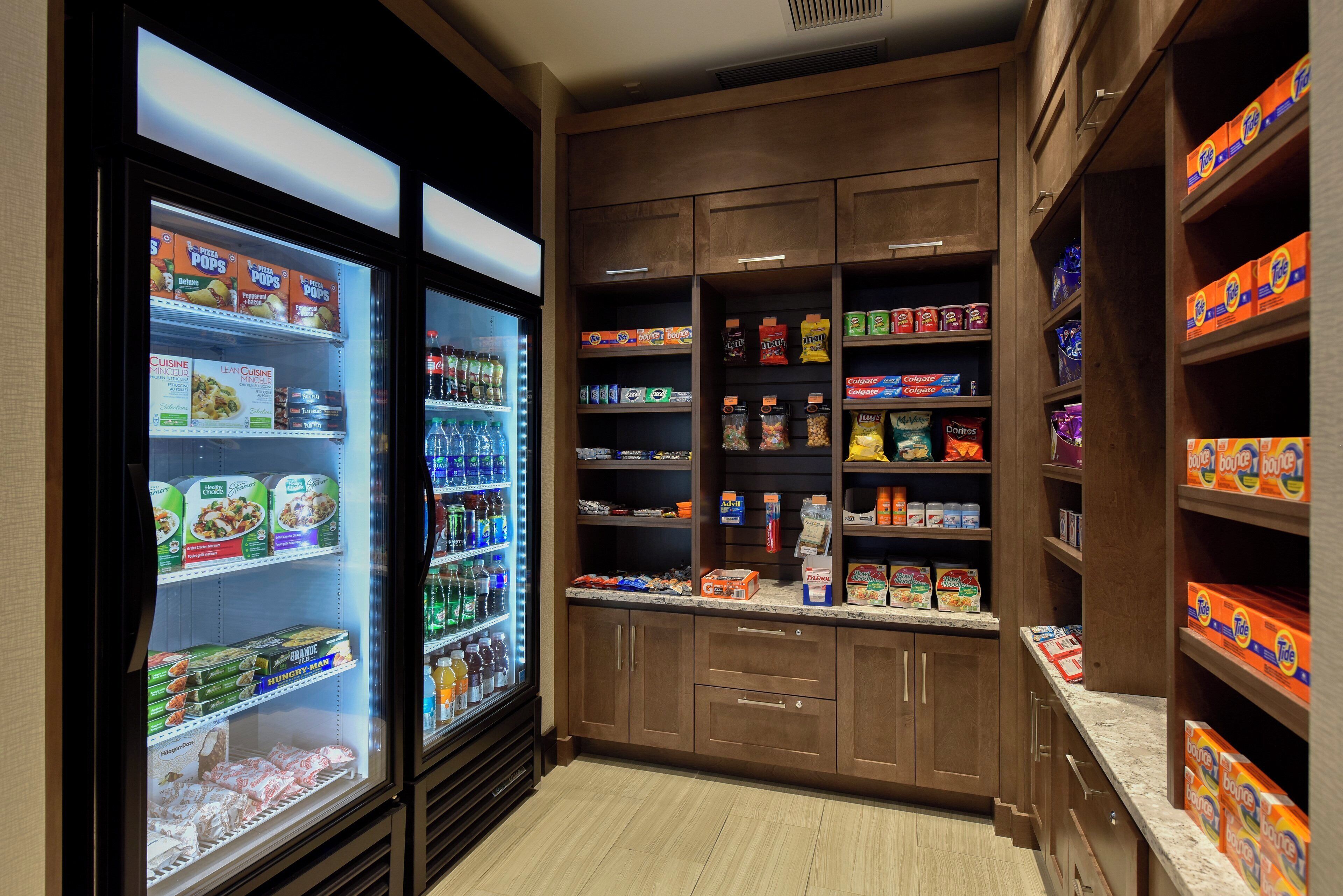 A self-service snack and beverage area with refrigerated sections and shelves stocked with various products.