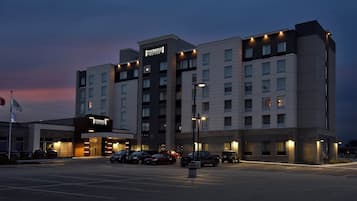 A Staybridge Suites hotel with multiple floors, a parking lot, and a clear sky.