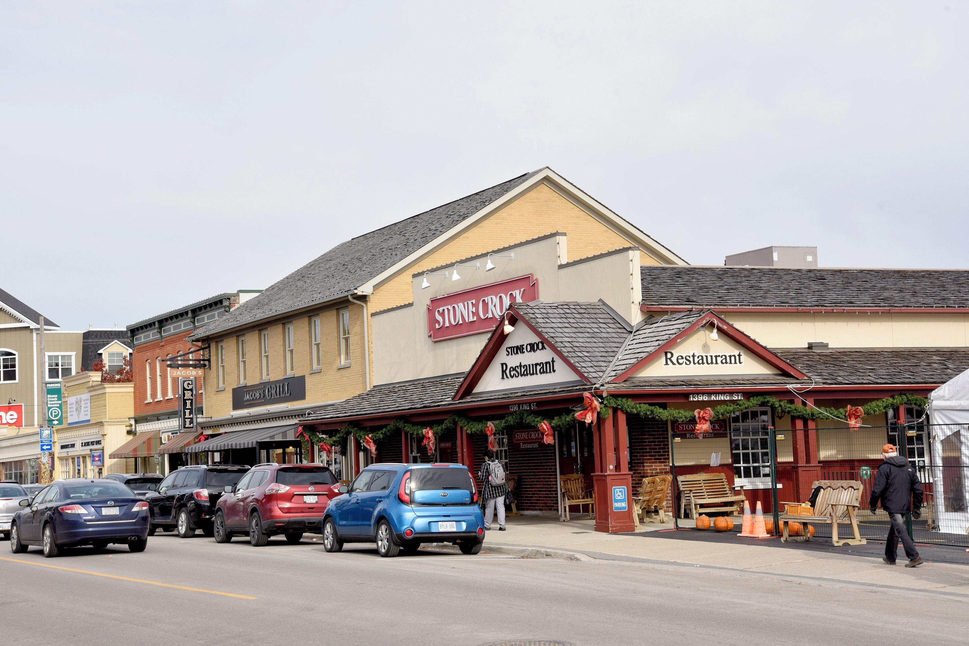 A street view with a restaurant named 'Stone Crock Restaurant' and a parking sign for 'Jacob's Grill.'