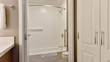 A bathroom with a bathtub, toilet, and a shower area.