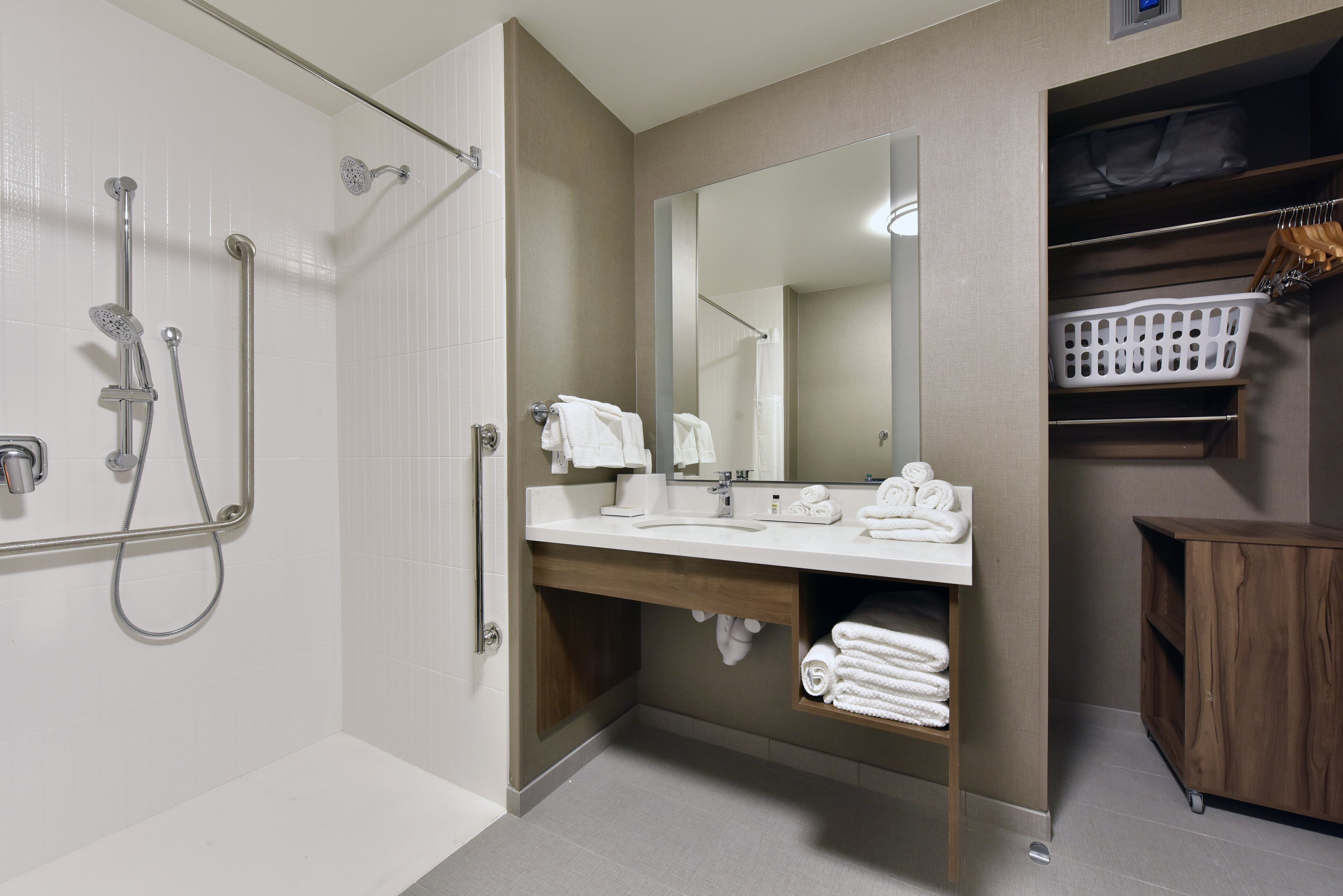A modern bathroom with a shower, sink, and mirror.