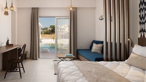 A modern hotel room with a bed, a desk, and a view of a pool and buildings. - Nama Retreat (Rhodes)