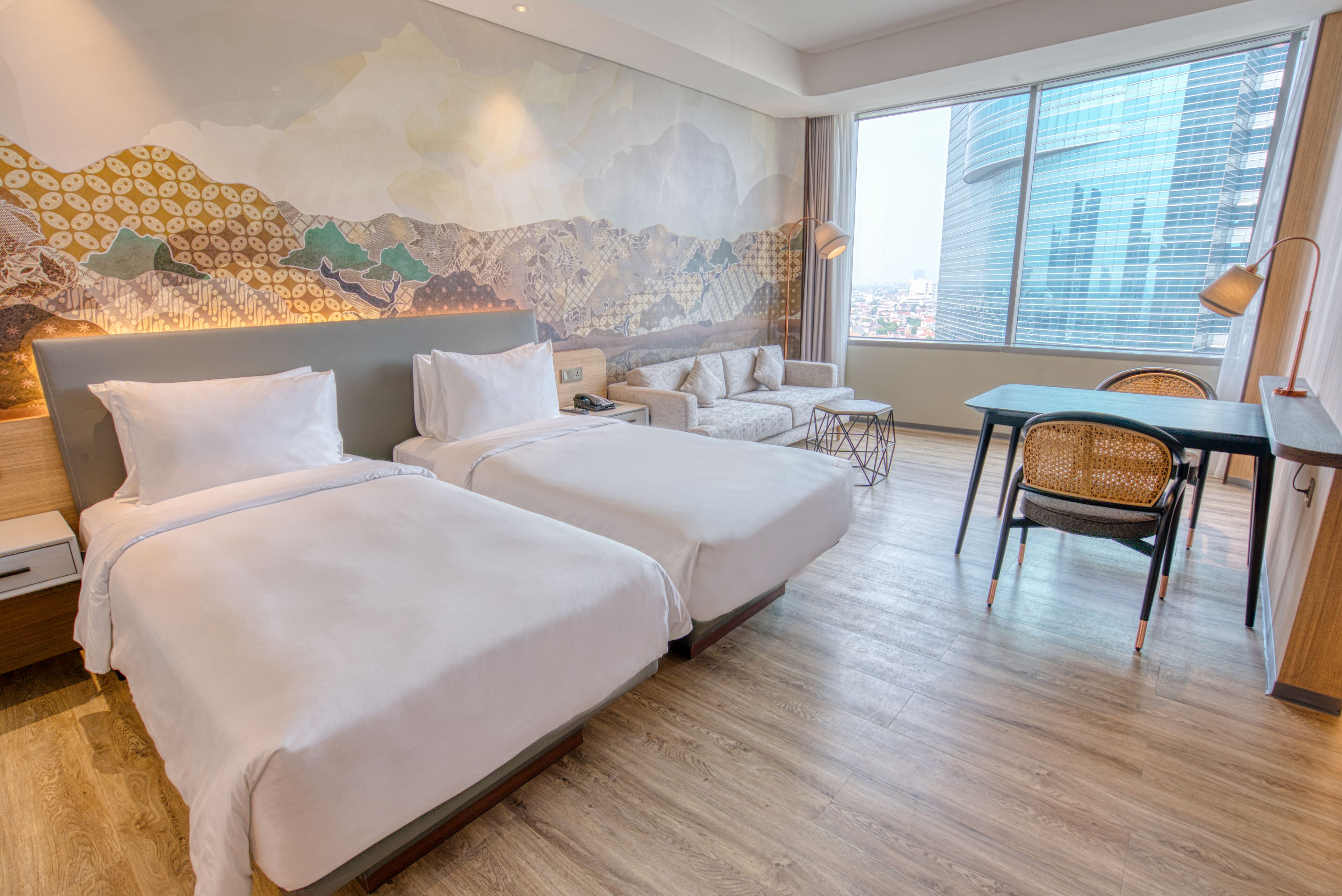 Una habitación de hotel con dos camas, un sofá, una mesa de comedor y una silla.