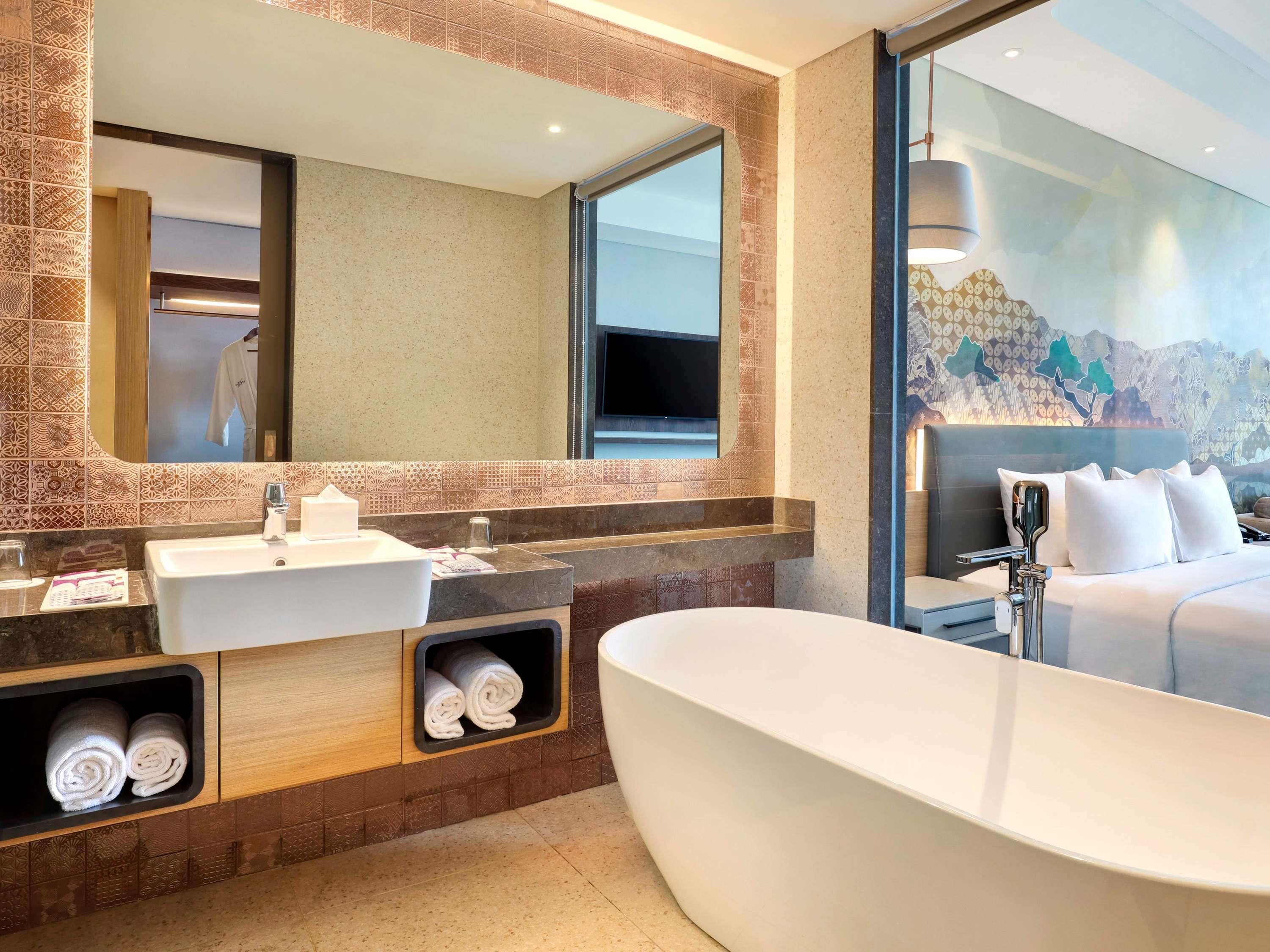 Un baño moderno con una bañera grande, un tocador con espejo y una zona de ducha.