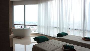 Enjoy a panoramic city view from the comfort of your room, featuring a bathtub and two beds.