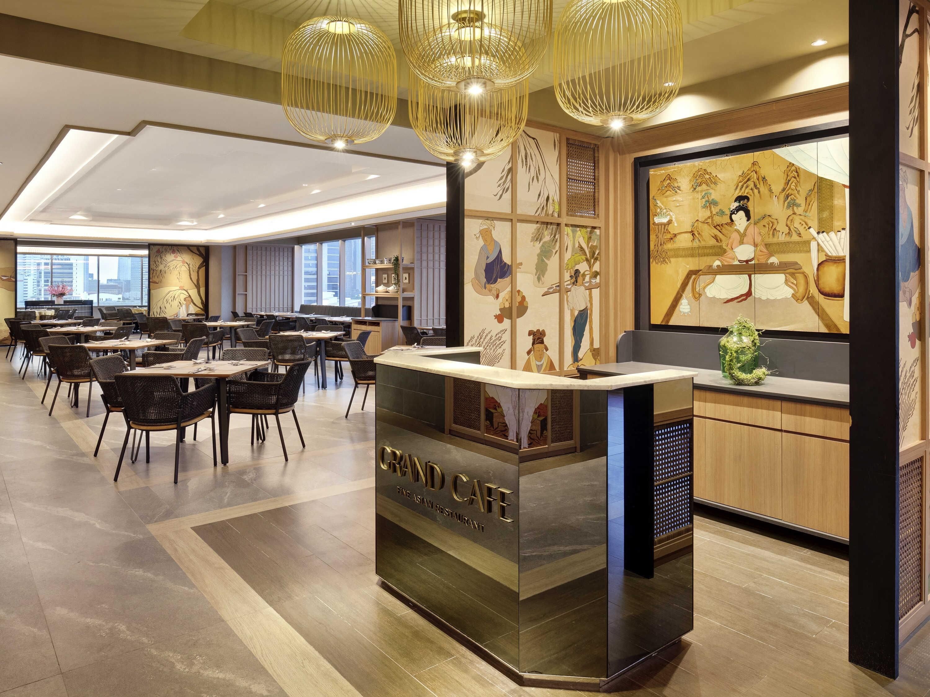 A modern restaurant with a reception desk, dining tables, chairs, and a view of the cityscape.