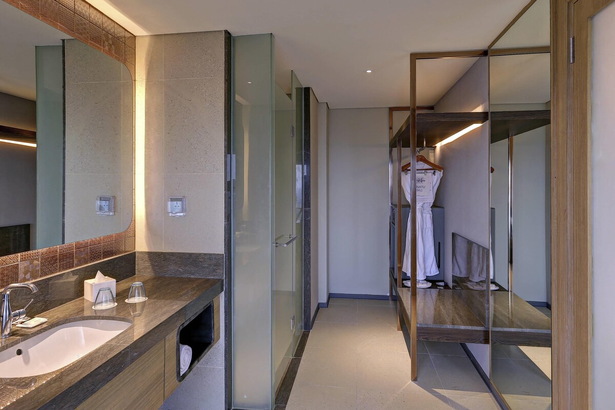Een moderne badkamer met een grote spiegel, een wastafel en een douchecabine van glas.