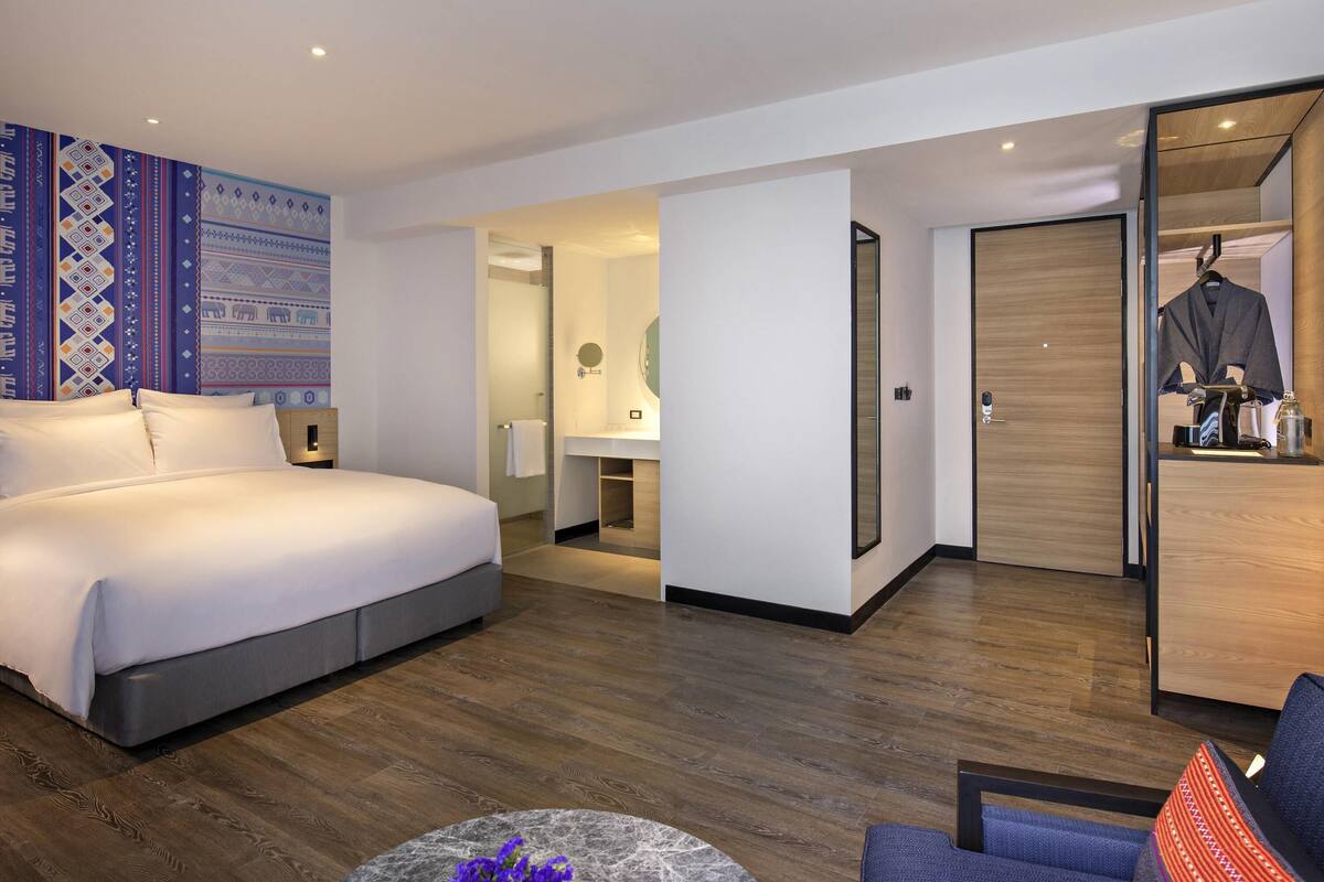Une chambre d’hôtel moderne, dotée d’un grand lit, d’un bureau et d’une armoire.