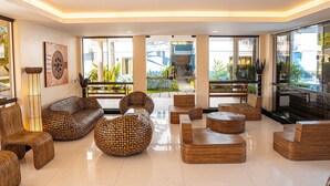 Un hall amplio con mobiliario moderno, ventanas grandes y vistas al exterior.