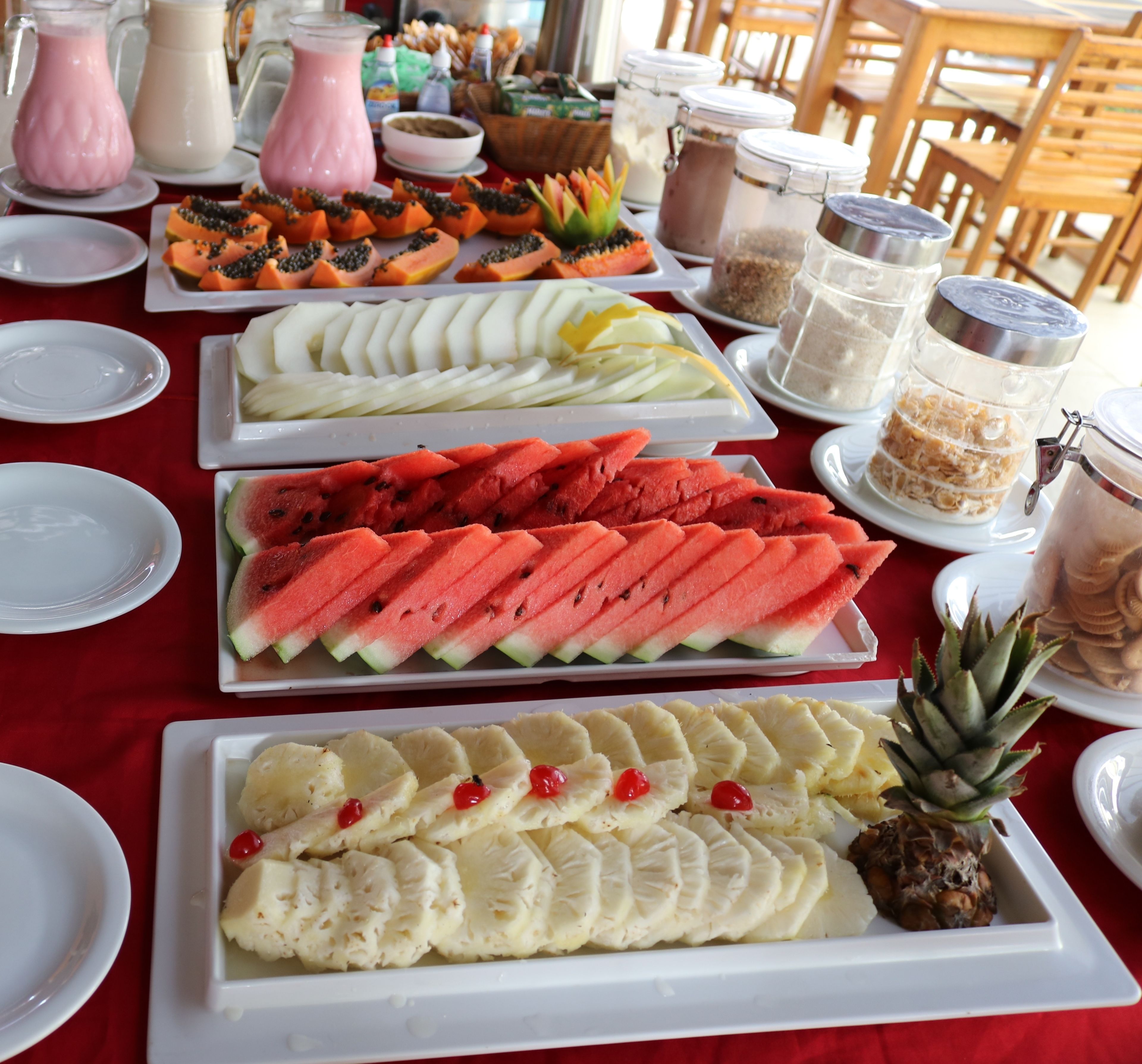 Une table de buffet proposant une variété de fruits et de boissons.