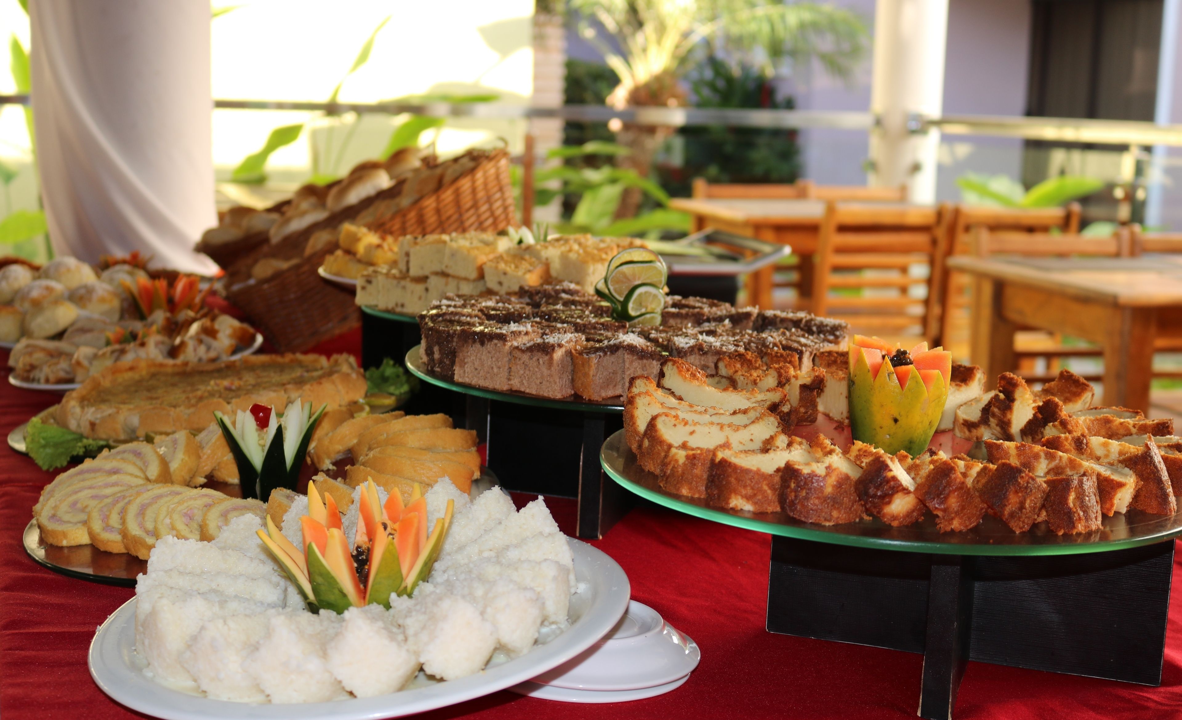 A buffet table with various desserts and a plate of white food garnished with fruit.