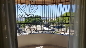 A balcony with a wrought iron railing, a view of a residential area, and a clear sky. - Apartamento Florangel (Santo Domingo Este)