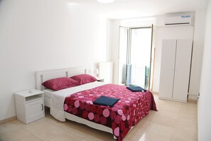 A bedroom with a bed, nightstand, wardrobe, and an air conditioning unit. - Palazzo Grigio (Bari)