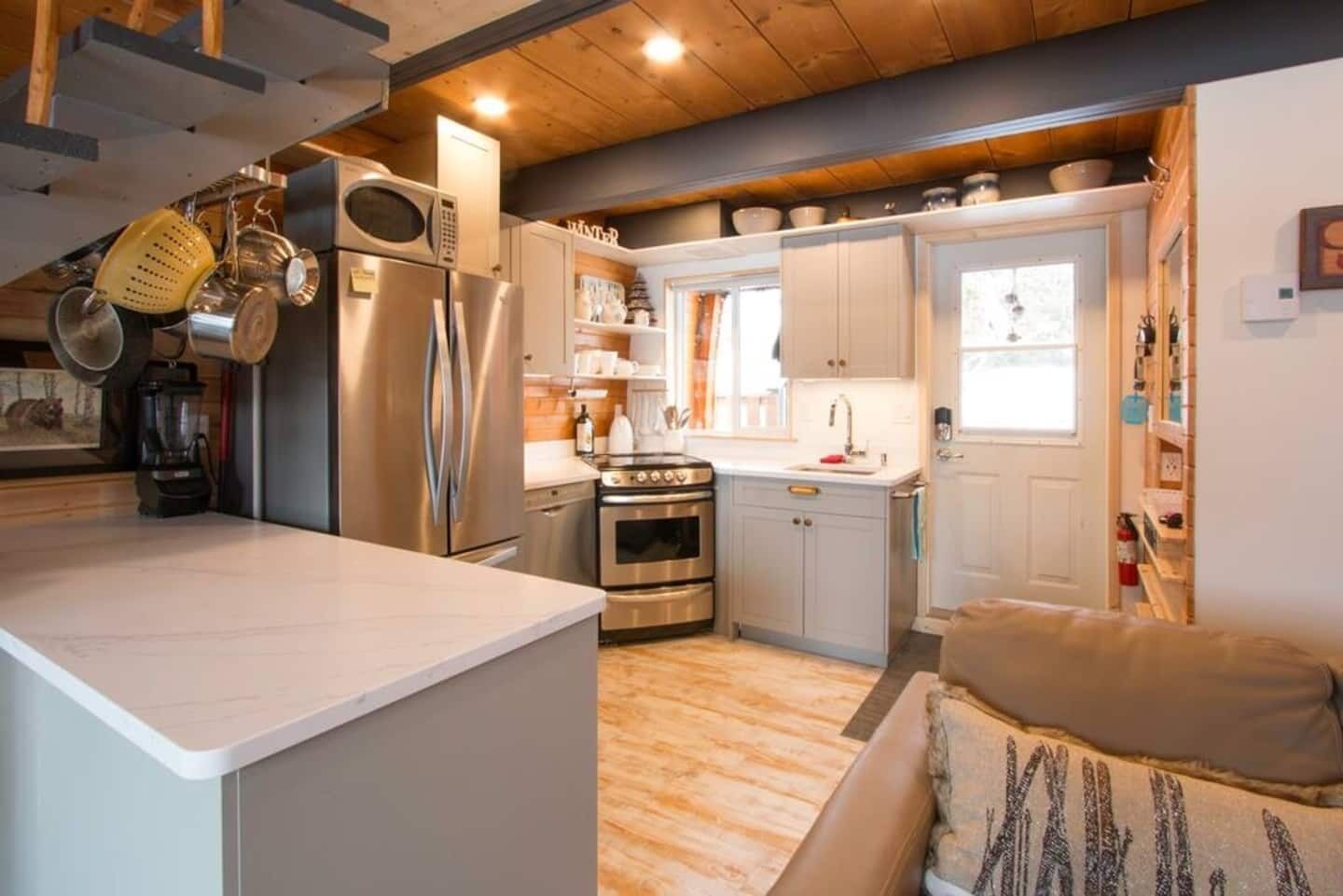 Une cuisine compacte dotée d’appareils électroménagers modernes, un coin repas et un espace salon confortable.