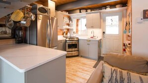 Een kleine keuken met moderne apparatuur, een eethoek en een gezellige zithoek.