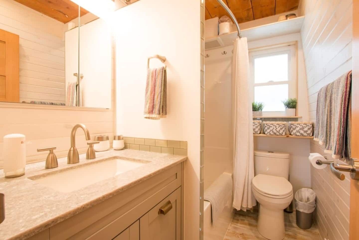Une salle de bain avec douche, toilettes et lavabo.