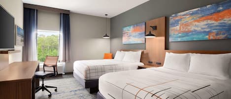 A hotel room with two beds, a desk, a chair, and large windows with curtains.