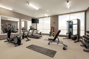A gym with treadmills, elliptical machines, a weight bench, and free weights. - La Quinta Inn & Suites by Wyndham Brunswick/Golden Isles (Brunswick)