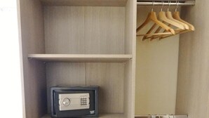 Ein Kleiderschrank mit mehreren Einlegeböden, einer Kleiderstange und einem kleinen elektronischen Gerät auf einem der Böden.