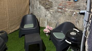 Una stanza rustica con pareti in mattoni, luci a stringa e una tenda.