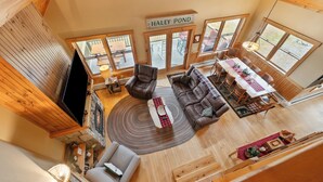 A spacious living area with a fireplace, a television, and a sign reading "HALLEY POND".