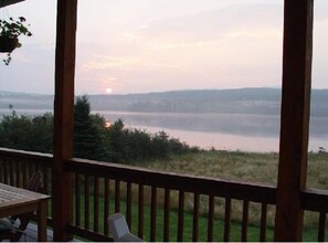 Relax on the lakeside deck with a serene view of the calm lake and distant horizon.