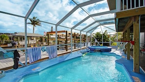Piscina interna com vista clara do céu, rodeada por um deck de madeira e cadeiras de descanso.