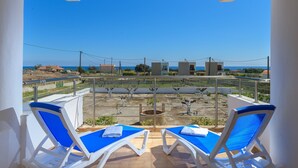 A balcony with two sun loungers, a view of the sea, and a clear sky. - Villa Valasia in Gennadi (Gennadi)