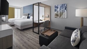 Een moderne hotelkamer met twee bedden, een bureau, een bank en een televisie.