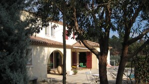 Una casa con un patio, un espacio de estar techado y una puerta visible.