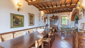 A dining area with a long wooden table, wicker chairs, and a rustic ceiling. - Beautiful home in Moncioni with private swimming pool, can be inside or outside (Moncioni)