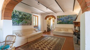 A living room with two sofas, a patterned rug, and a painting of flowers. - Beautiful home in Moncioni with private swimming pool, can be inside or outside (Moncioni)