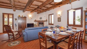 A dining area with a wooden table set for four, surrounded by wicker chairs. - Il cacciatore di lucciole (Montecchio)