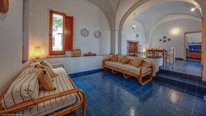 A spacious living area with a sofa, a wicker chair, a dining table, and a fireplace. - Wonderful seaview w/ direct sea access & jacuzzi (Leuca)