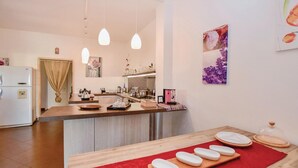 A modern kitchen with a central island, pendant lighting, and a coffee machine. - Amazing home in Modica with WiFi (Modica)