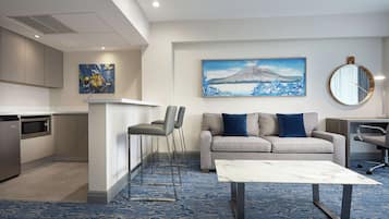 A modern living room with a sofa, coffee table, and artwork on the wall.