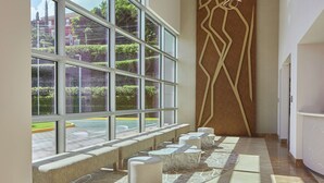 A modern interior with large windows, a patterned floor, and a unique wall art piece. - DoubleTree by Hilton Managua (Managua)