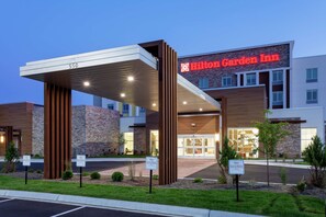 A Hilton Garden Inn with a modern design, featuring a stone facade and a covered entrance. - Hilton Garden Inn St. Cloud (Waite Park)