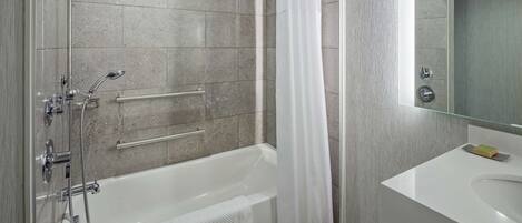 A modern bathroom with a bathtub, shower, and sink.