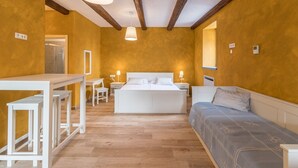A bedroom with a bed, bedside tables, a desk, and a chair.