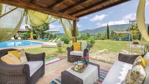 A covered outdoor seating area with wicker furniture, a pool, and a view of the countryside. - Amazing home in Montebuono (Montebuono)