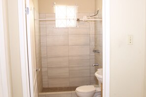 A small, enclosed shower stall with a toilet and sink. - Your Holiday Home Caribbean Estates (Portmore)