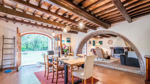 A rustic dining area with a wooden table, chairs, and hanging light fixtures. - Lovely home in Suvereto -LI- (Suvereto -LI-)