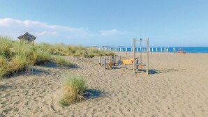 A beach with sand, grass, a swing set, and a small structure. - Lovely home in Suvereto -LI- (Suvereto -LI-)
