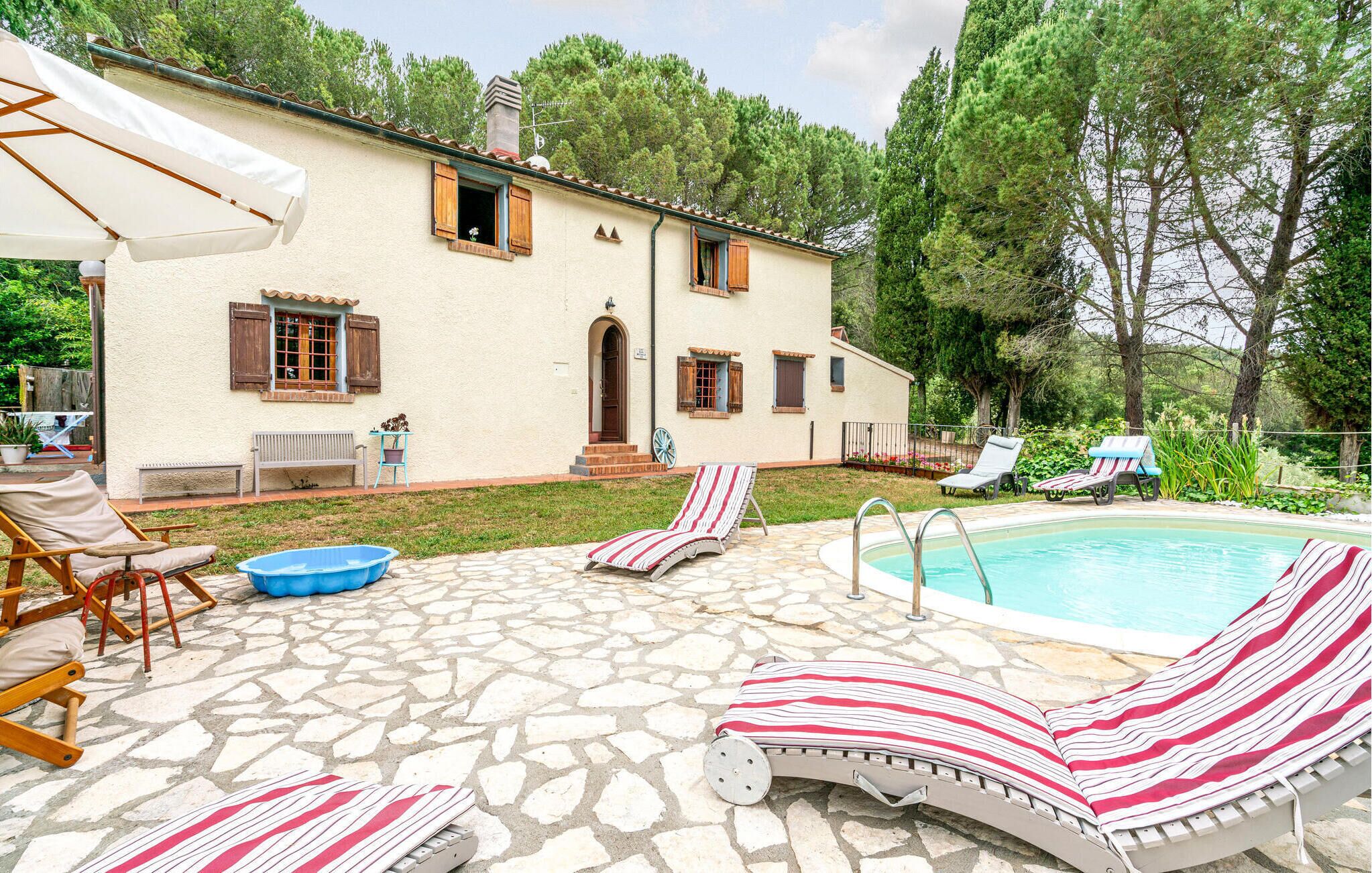 A villa with a stone patio, a swimming pool, and outdoor seating.