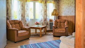 A living room with two leather armchairs, a wooden coffee table, and a patterned rug. - 4 bedroom stunning home in Mariannelund (Mariannelund)