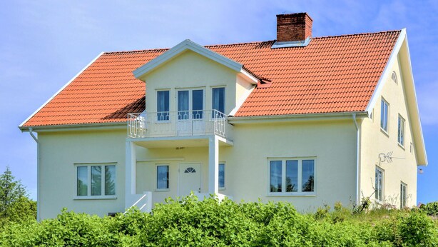 A two-story house with a red-tiled roof, a balcony, and a chimney. - 4 bedroom stunning home in Mariannelund (Mariannelund)