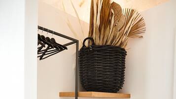 A wooden shelf with a woven basket containing dried plants.