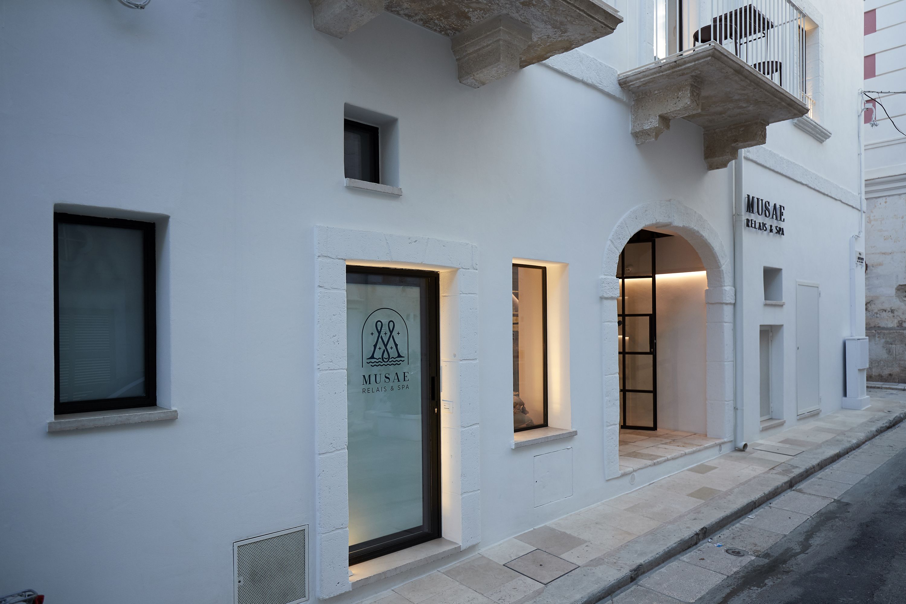 Een gebouw met een moderne gevel, met een spa en wellnesscentrum genaamd "MUSAE RELAX & SPA".