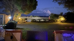 A nighttime outdoor setting with a wooden fence, a tree, and a distant mountain range. - Stunning House Between the Countryside and the Sea - Southern Sardinia CIN: IT111070C2000U0960 (Porto Pino (Sardegna))